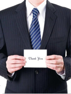 Man holding a thank you note, critical to landing a job